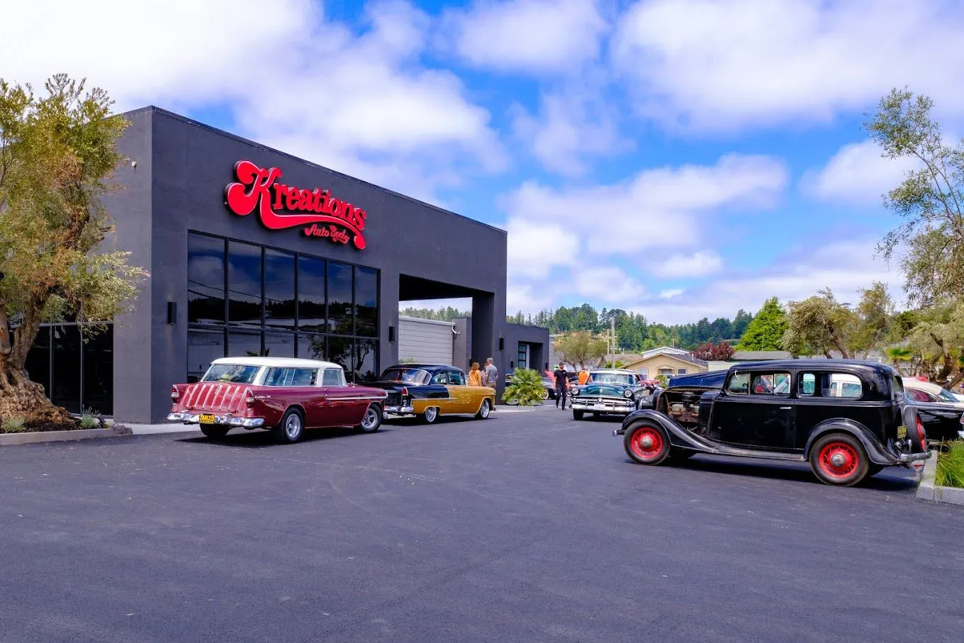 Classic cars lined up in front of the Kreations Auto Body shop in Fortuna during a community cruise
