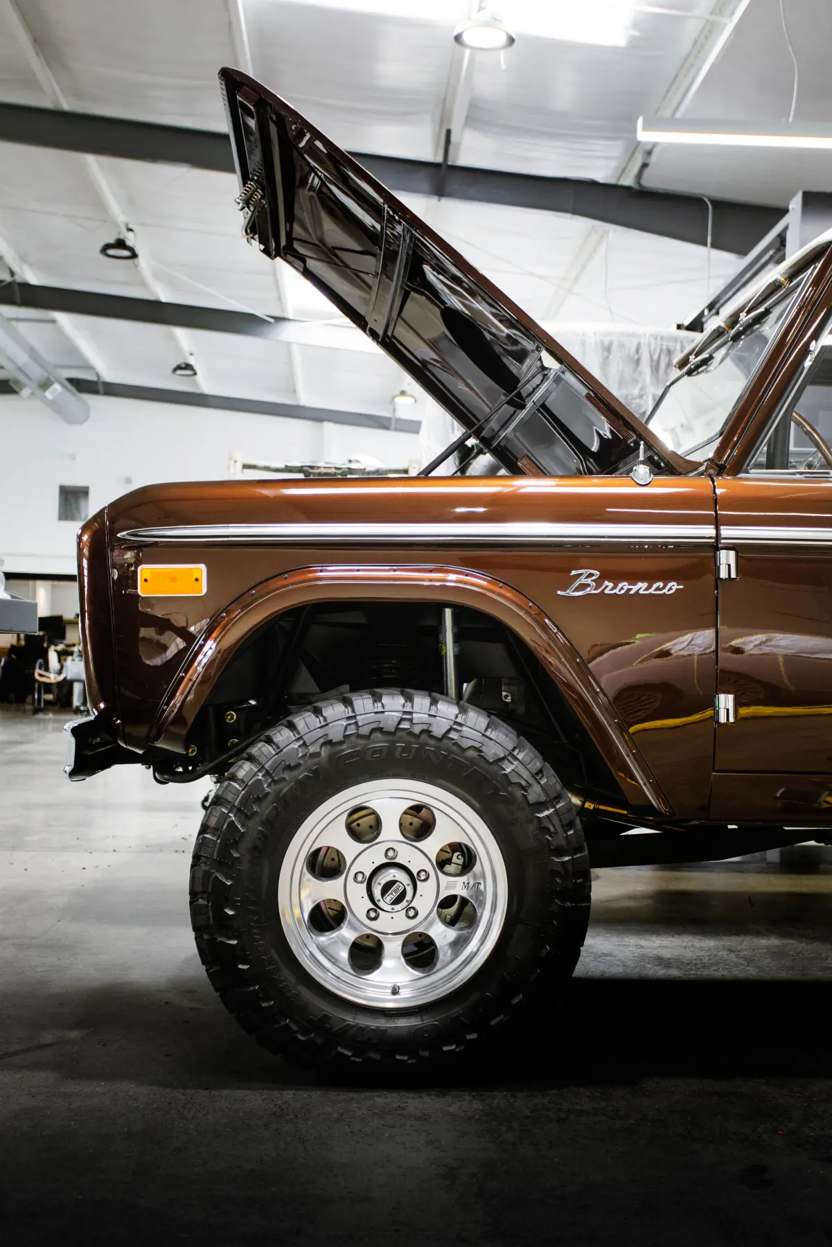 Brown early Ford Bronco on all-terrain tires at Kreations Auto Body