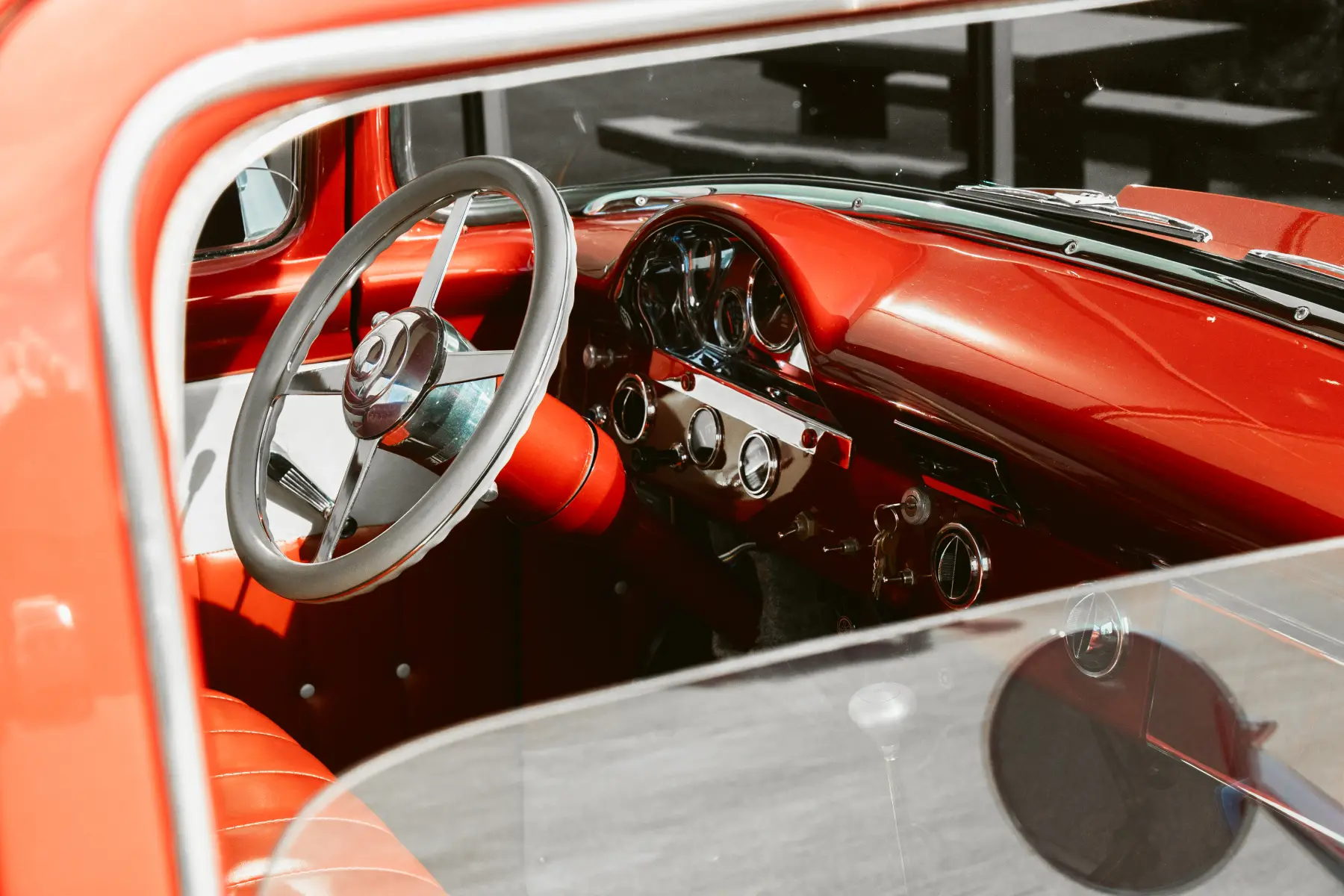 Red leather cockpit and wood-rimmed wheel in a Kreations Auto Body custom build